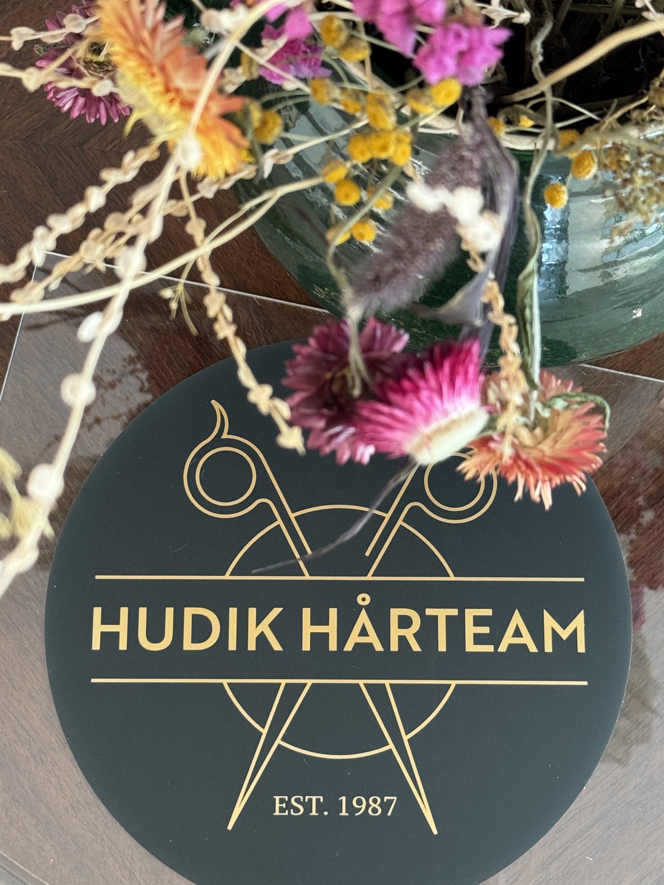 Hudik Hårteams emblem med blommor